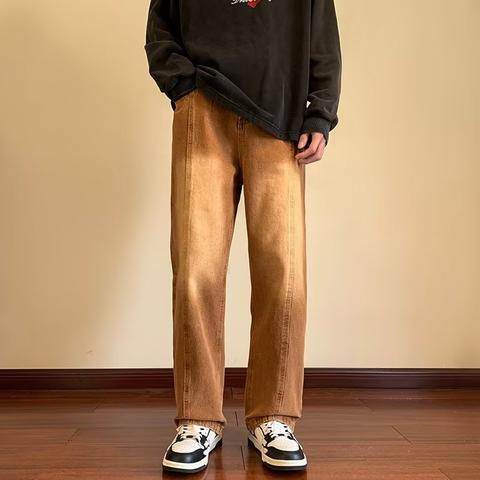 Bărbat purtând Pantaloni drepți vintage prespălați maro cu croială dreaptă hanorac negru și adidași casual