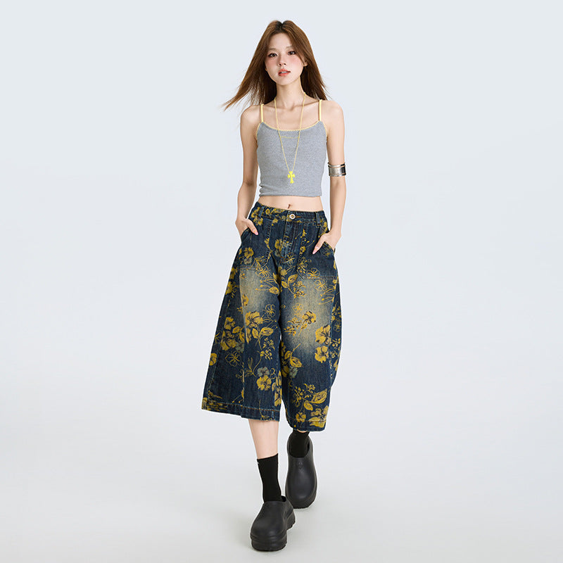 Model purtând Blugi largi cu print floral bleumarin cu flori galbene, croi culotte, top gri casual