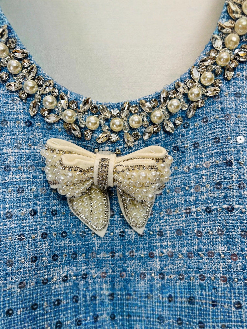 Close-up of the Sequined Bow Sleeess Vest Dress featuring a jeweled neckline and decorative bow