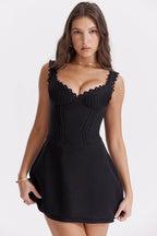 Rochie scurtă casual neagră tip corset cu decolteu dantelat și fustă evazată purtată de model