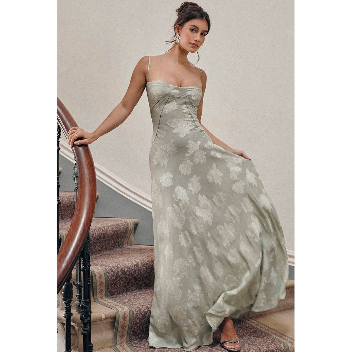 Rochie lungă Eternal Grace verde pal cu imprimeu floral, corset satinat si bretele subtiri, purtată pe scară