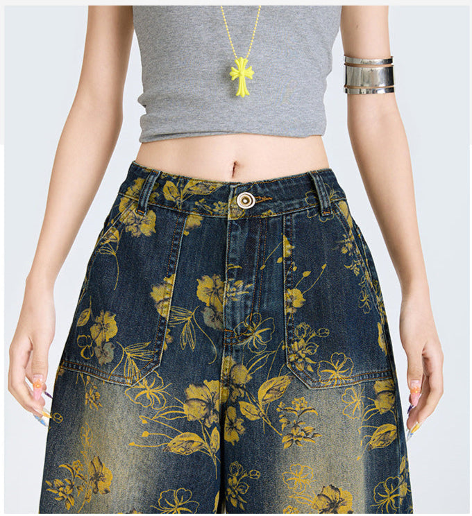 Model purtand Blugi largi cu print floral galben pe denim inchis talie inalta si buzunare frontale