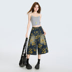 Model purtand Blugi largi cu print floral din denim bleumarin cu flori galbene croi lejer talie inalta