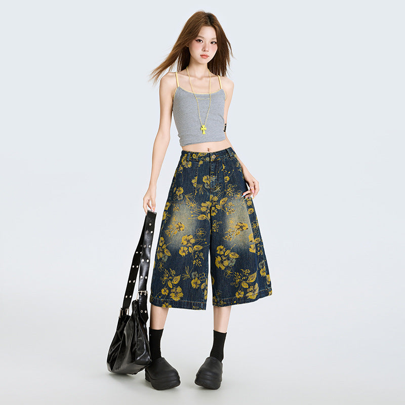 Model purtand Blugi largi cu print floral din denim bleumarin cu flori galbene croi lejer talie inalta