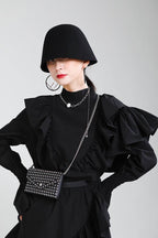 Fashionable model wearing an Asymmetric Dress with Ruffles, featuring bold sleeves and stylish accessories.