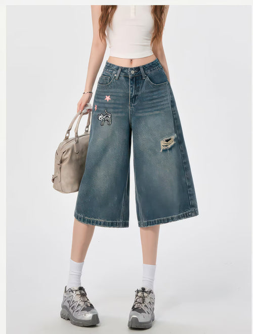 Model purtând Blugi evazați "Funny Kitten" din denim cu broderie pisică, ruptură și croială culotte