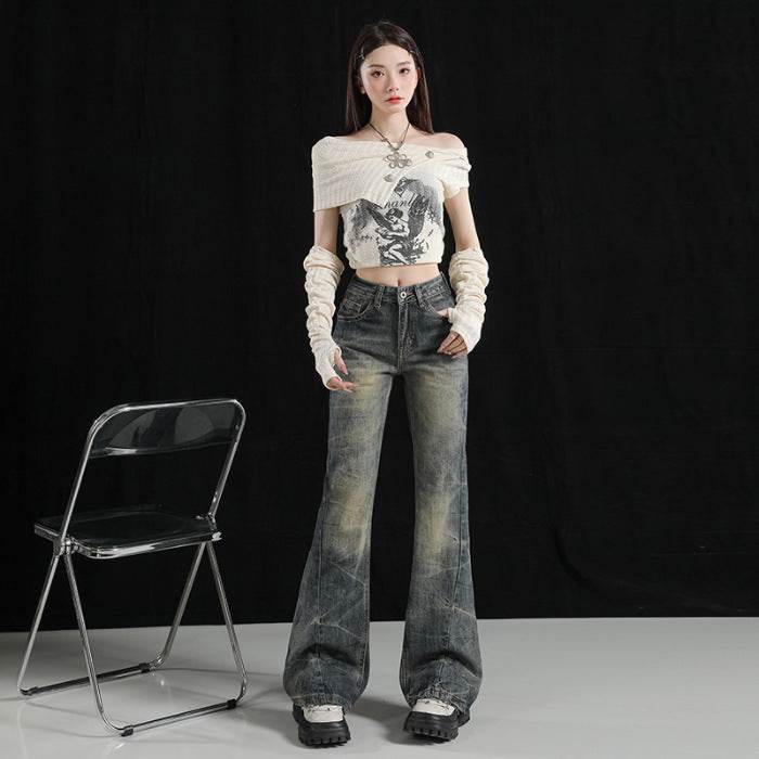 Model purtând Pantaloni evazați cu aer retro și uzură artistică. Top scurt off shoulder, mănuși albe, pantofi groși, fundal negru.