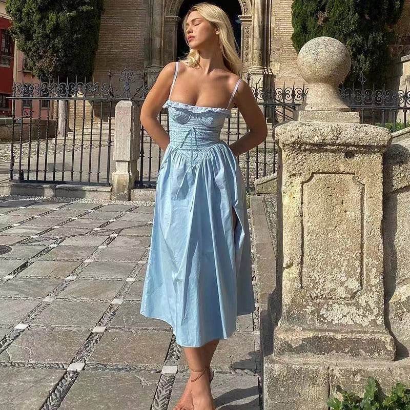Rochie de vară lungă stil vintage. Model blond în curte poartă rochie bleu cu bretele subțiri, corset și fustă evazată midi