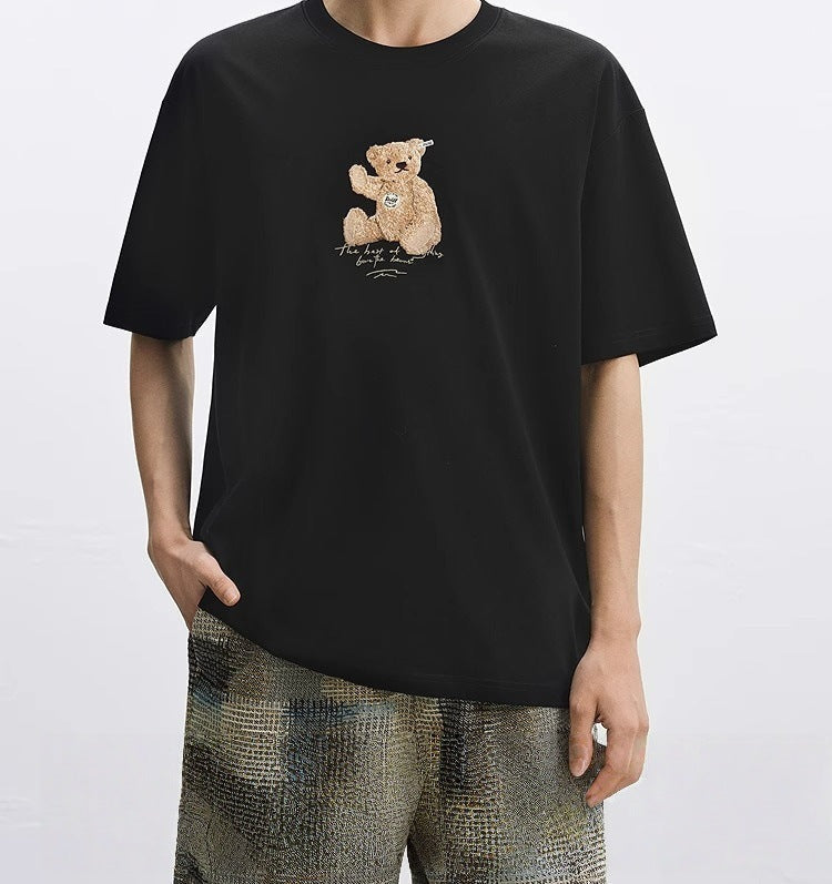 Tricou cu urs brodat negru AM Vision RO model oversize cu ursulet brodat central pe piept purtat cu pantaloni casual