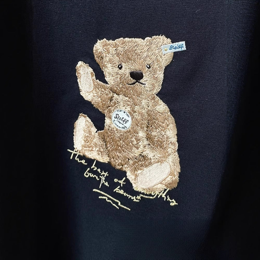Tricou cu urs brodat maro pe material bleumarin detaliu pufos si eticheta decorativa