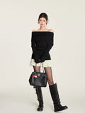 Stylish black knitted sweater dress with spliced skirt, paired with knee-high boots and a chic handbag