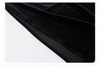 Close-up of the hem detailing of a black velvet dress with beads showcasing luxurious fabric quality