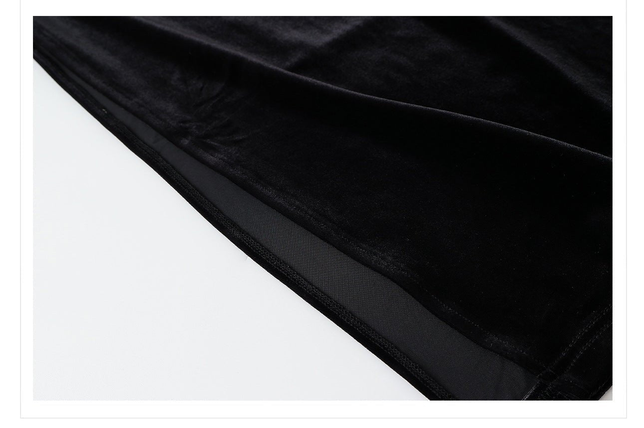 Close-up of the hem detailing of a black velvet dress with beads showcasing luxurious fabric quality