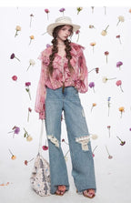 Model wearing Blossom Whisper Ruffled Chiffon Blouse paired with vintage jeans and a wide-brimmed hat