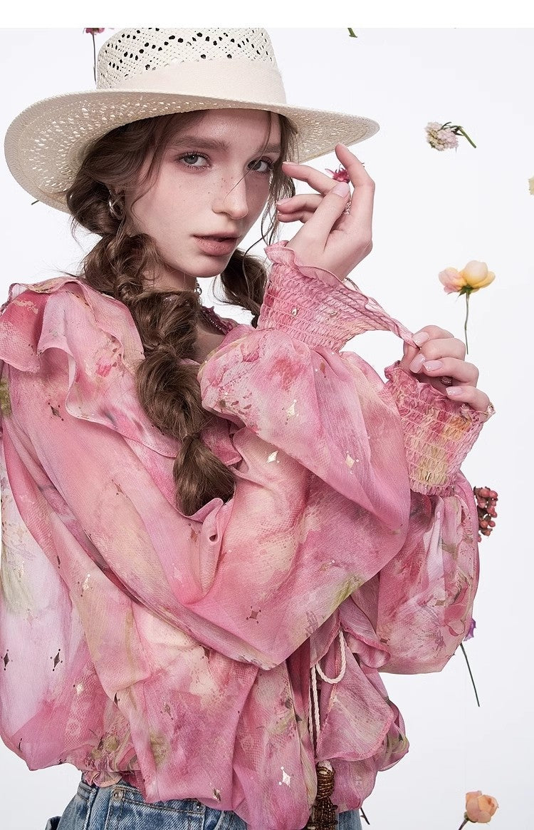 Model wearing a Blossom Whisper Ruffled Chiffon Blouse in pink with floral prints and ruffled sleeves