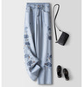 Blue Lotus Retro Embroidered Jeans with floral design, paired with a black handbag and slip-on shoes