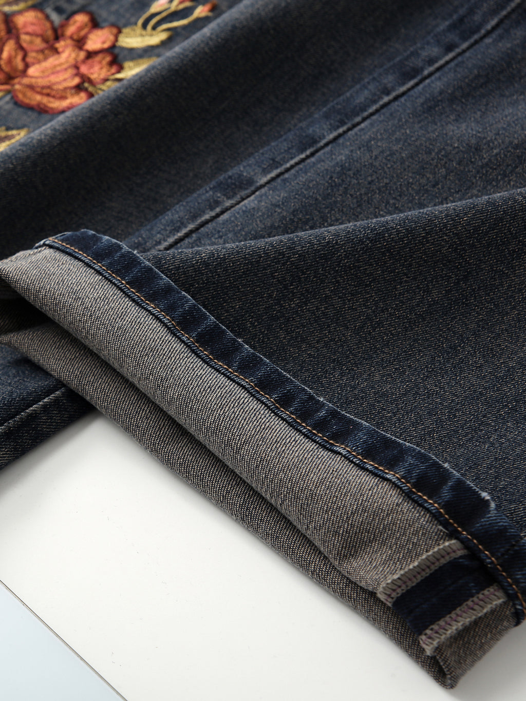 Close-up of Blue Sakura Embroidered Wide Leg Jeans showcasing intricate floral embroidery and denim texture