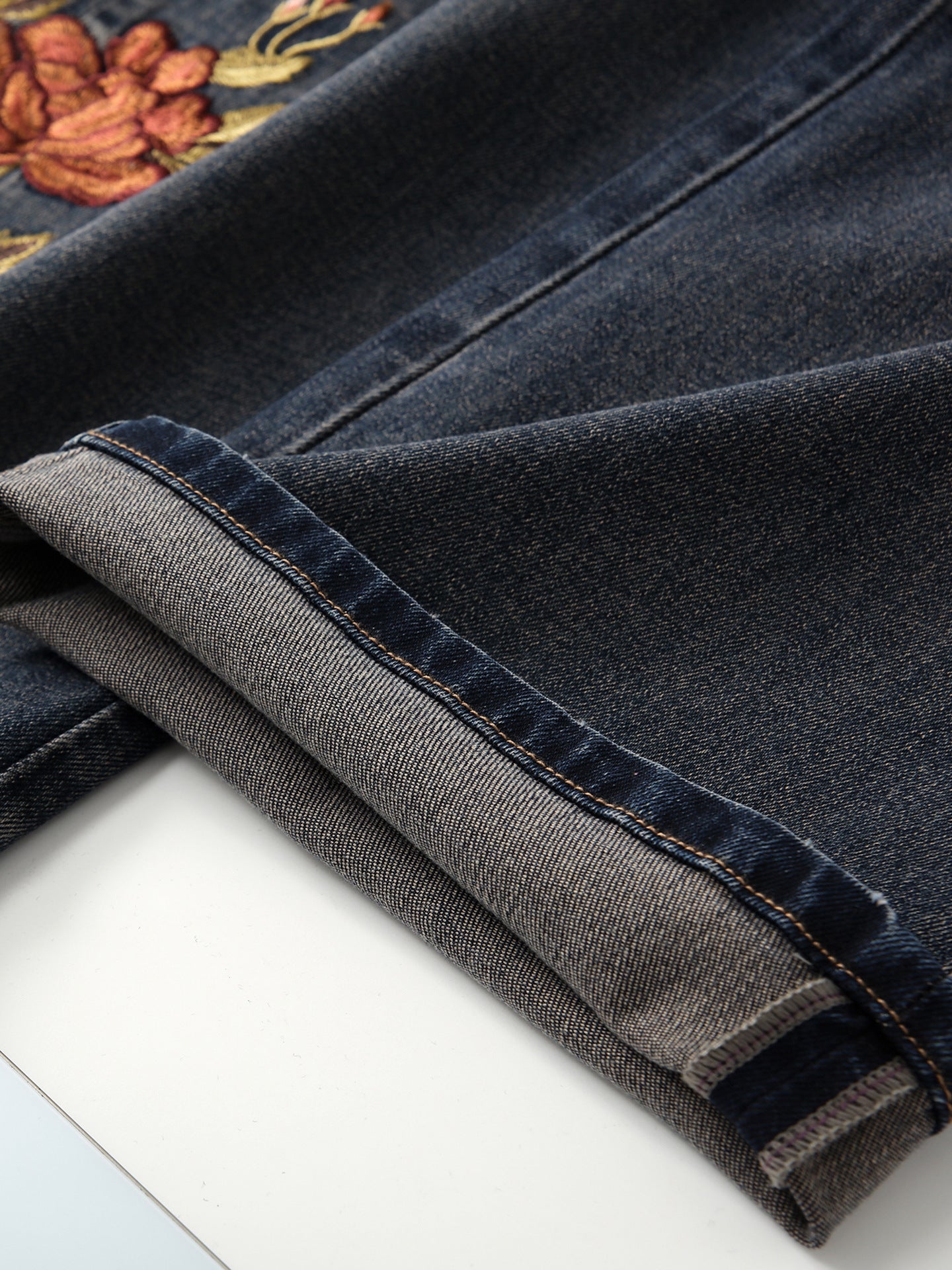 Close-up of Blue Sakura Embroidered Wide Leg Jeans showcasing intricate floral embroidery and denim texture