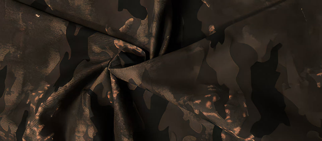 Pantaloni "Camouflage Flare" detaliu material camuflaj maro inchis texturat pliuri si finisaj mat