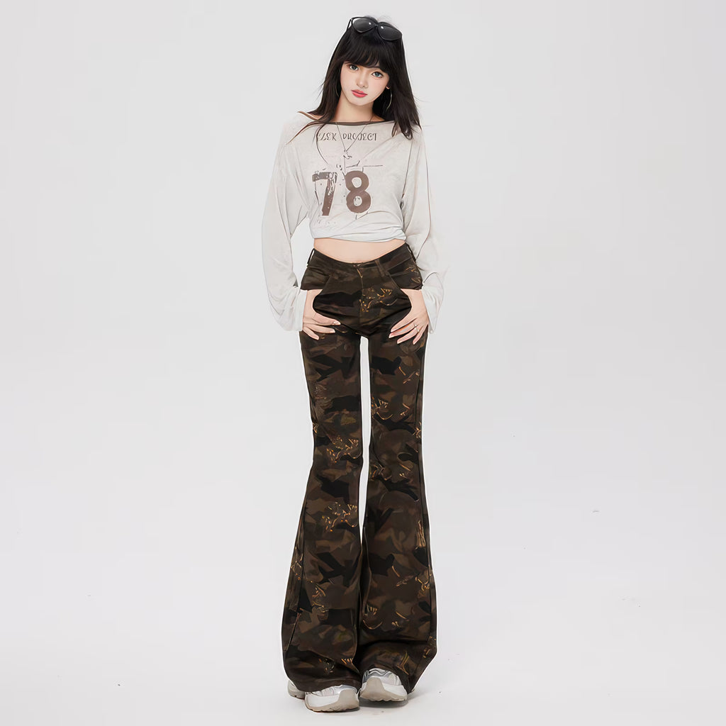Model tânăr purtând Pantaloni "Camouflage Flare" din material camuflaj evazați, talie înaltă, pantofi sport.