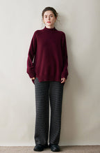 Burgundy AM Vision RO cashmere turtleneck sweater for women paired with striped wide-leg pants