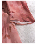 Close-up of Dark Pink Silk Tie Dress fabric with floral patterns and soft texture