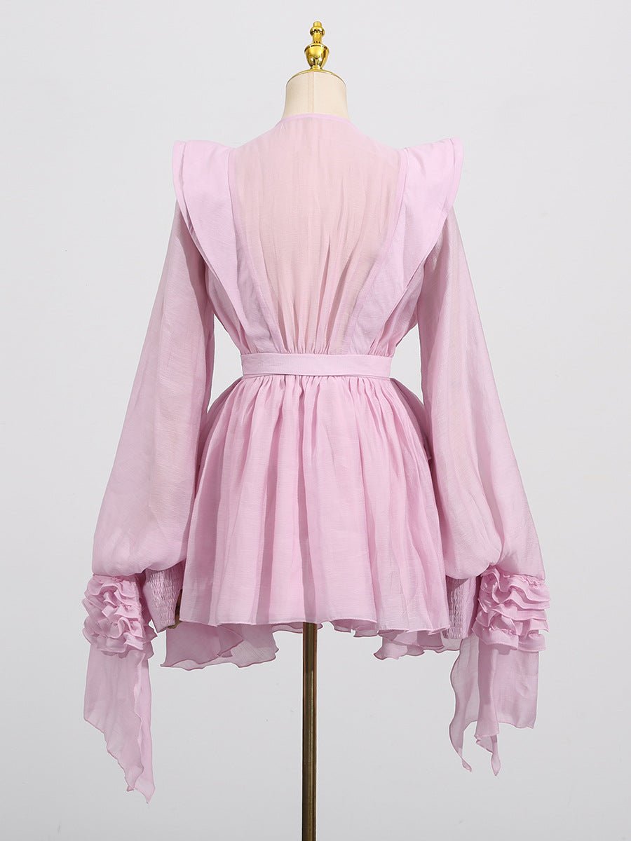 Elegant pink dress with asymmetric design and cut-out details featuring flowing sleeves and a cinched waist