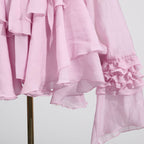 Pink Dress with Asymmetric Design and Cut-Out Details featuring ruffled sleeves and a flowing silhouette
