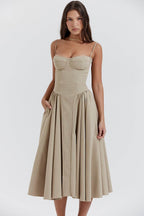 Light beige dress with minimalist design and flared skirt, featuring adjustable straps and pockets