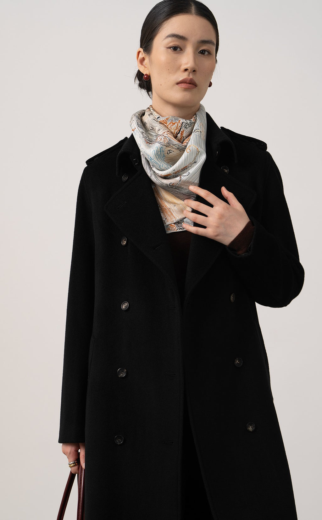 Elegant Elara Wool Coat Cashmere X Mulberry Silk in black, styled with a patterned scarf for a refined look.