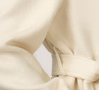 Close-up of the Elara Wool Coat Cashmere X Mulberry Silk with cinched waist detail