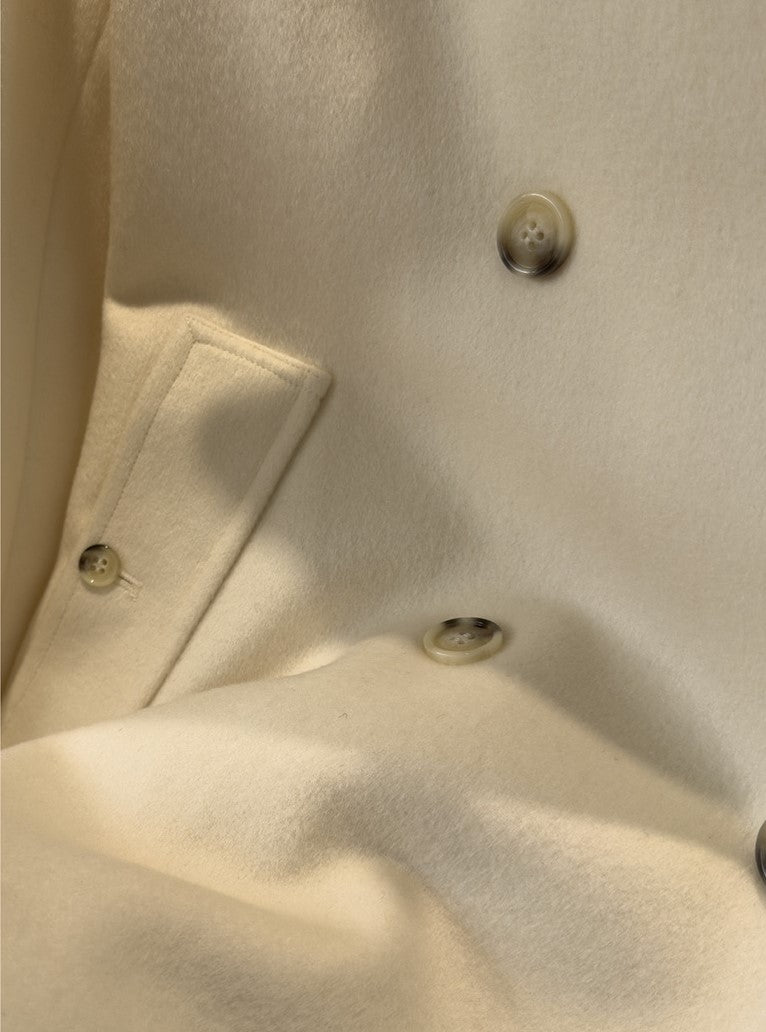Close-up of the Elara Wool Coat Cashmere X Mulberry Silk featuring elegant buttons and soft fabric texture