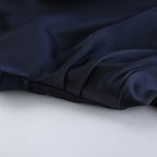 Close-up of silky fabric showcasing the Elegant Bell Sleeve Dress in deep navy color