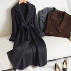 Elegant Wool And Cashmere Coat With Fitted Cut And Suit Collar in black and brown displayed on a cozy chair