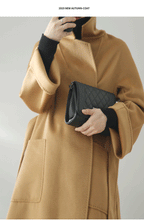 Eloane Elegant Ripple Wool Coat in camel color, featuring a relaxed fit and pockets, paired with a stylish handbag