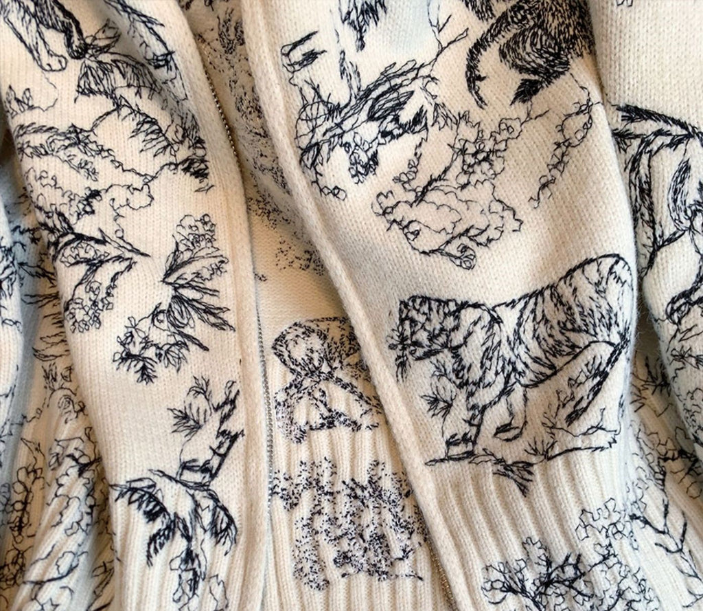 Detailed design of AM Vision RO Emblem Knit Zip Jacket featuring intricate animal and nature patterns