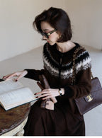 Woman reading a book while wearing a stylish Fair Isle Core Cardigan in brown and black patterns