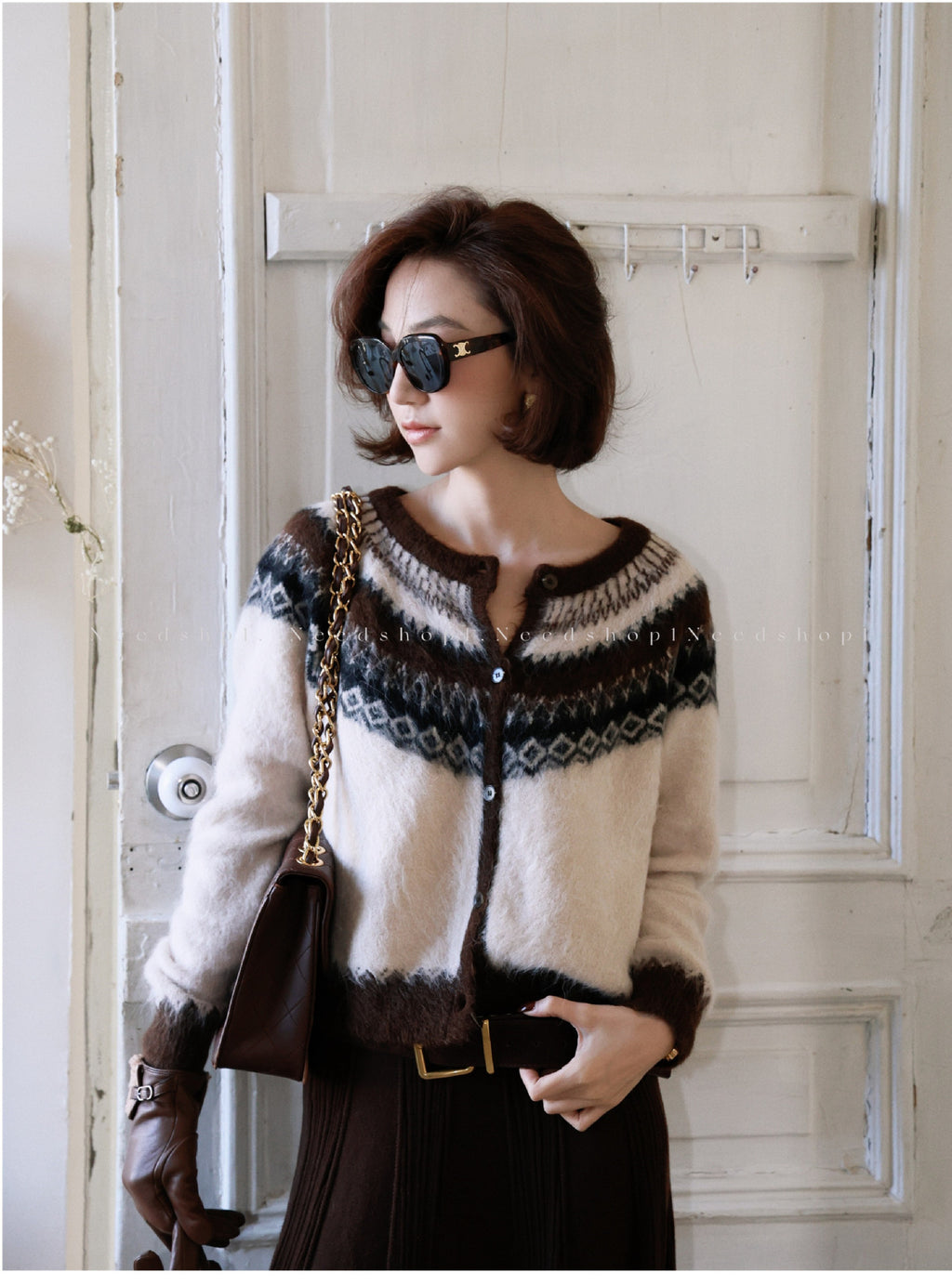 Stylish woman wearing a Fair Isle Core Cardigan with intricate patterns, paired with sunglasses and a chic handbag