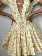 Floral Summer Dress in yellow with a v-neck and pleated skirt, perfect for warm weather outings