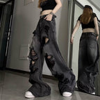 High waisted ripped baggy jeans in black denim styled with a crop top and belt for casual streetwear