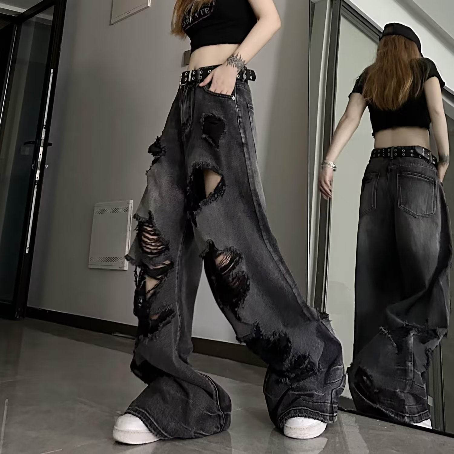 High waisted ripped baggy jeans in black denim styled with a crop top and belt for casual streetwear