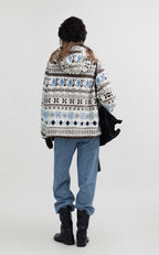Back view of a woman wearing a Hooded Winter Jacquard Jacket with a geometric pattern and casual jeans