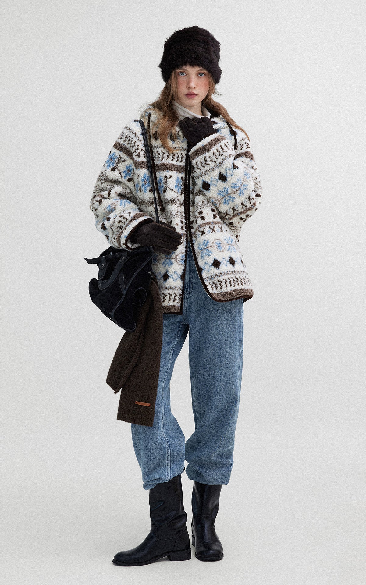 Woman wearing a Hooded Winter Jacquard Jacket with snowflake patterns and casual denim trousers