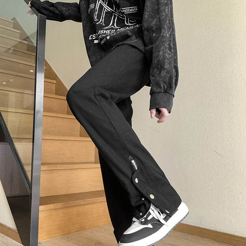 Casual street style black jeans with leg studs, paired with a graphic sweatshirt and sneakers