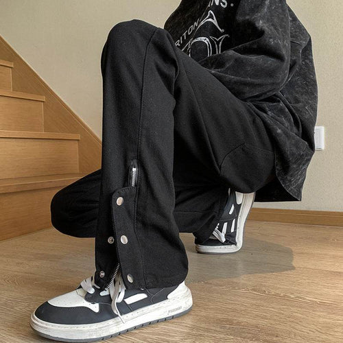 Black jeans with leg studs featuring zippered sides, perfect for a trendy urban look