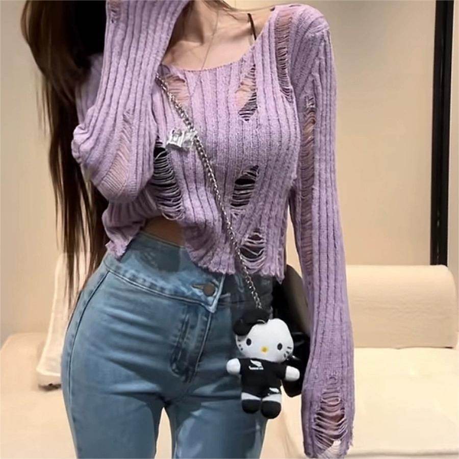 Fashionable purple knitted blouse with cut-outs and ribbed texture, styled with high-waisted jeans