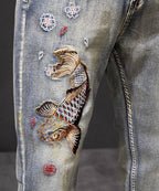 Koi Dynasty Embroidered Jeans featuring intricate koi fish and floral designs on a distressed denim fabric