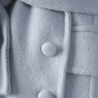 Detail of the Long Baby Blue Wool Coat featuring soft fabric and button closures for a stylish look