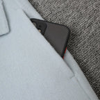 Close-up of Long Baby Blue Wool Coat pocket with a smartphone tucked inside for convenience