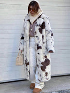 Stylish Long Faux Fur Effect Coat in Cow Print, perfect for adding warmth and glamour to winter outfits